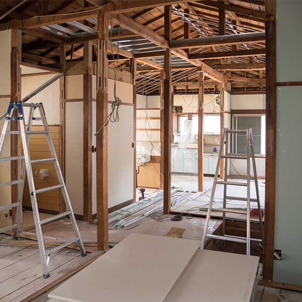 Servicio Mantenimiento y Renovación Habitación en obras con una estructura de madera y varias escaleras de aluminio.